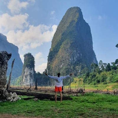 Person standing with open arms in Khao Sok.