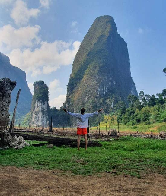 Person standing with open arms in Khao Sok.