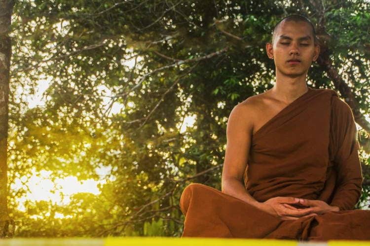 Buddhist monk meditating in the nature.